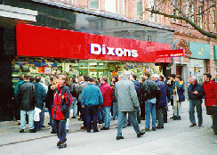 [people stood around in front of a shop]