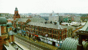 [Aerial view of Victoria Hall and redbrick shops and skyline]