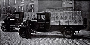 [lorry in cobbled street loaded with crates]