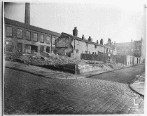 [cobbled road, partly demolished buildings]